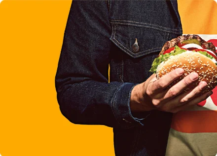 손으로 와퍼를 들고 있는 남성의 상체 이미지